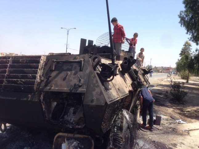 Children playing on destroyed Iraqi army tank August 2014 after it withdrew at Isis advances. 